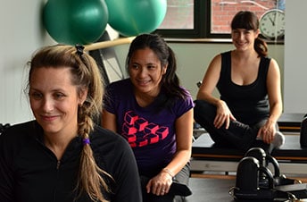 3 jeunes femmes effectuant des exercices sur reformer