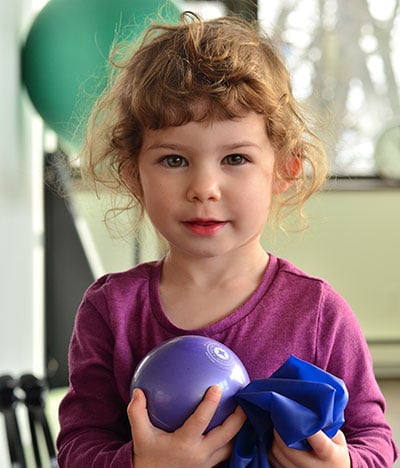 toddler with ball and flex band