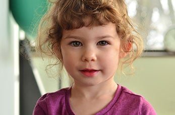 photo portrait d'une fillette aux cheveux chatains bouclés